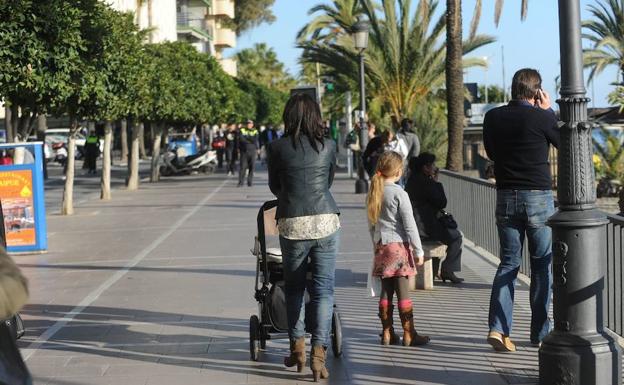 Una mujer pasea con su bebé en Marbella. 