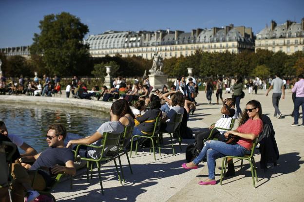 Turistas disfruta del sol en el Jardín de las Tullerías, en el centro de la capital francesa. :: reuters