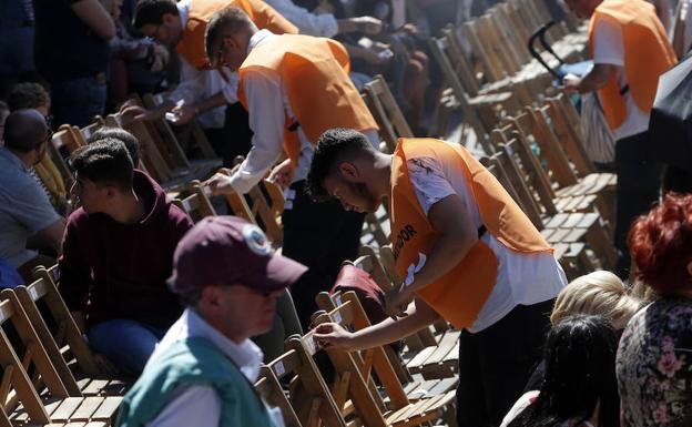 Imagen principal - Acomodadores numerando las sillas; protestas del público por las vallas en el recorrido, y material entre las sillas 