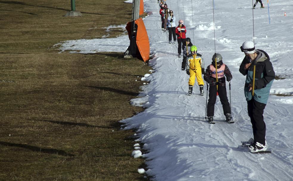Esquiadores se desplazan en una percha en una estación eslovena donde escasea la nieve.
