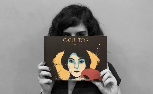 Laura Pérez posando tras su cómic 'Ocultos'.