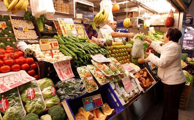 Una señora comprando en una frutería.