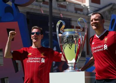 Imagen secundaria 1 - Arriba, los exfutbolistas Morientes y Solozabal y la primera teniente de alcalde en funciones de Madrid, Marta Higueras, posan con la Champions en la Plaza Mayor. En las imágenes inferiores, dos aficionados del Liverpool, junto al trofeo. 