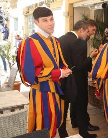 Imagen secundaria 2 - Los alrededores de la Aduana están tomados por los camiones, caravanas y vehículos de apoyo para el rodaje de la serie. Abajo, a la derecha, detalle de uno de los extras con el uniforme de la guardia pontificia. 