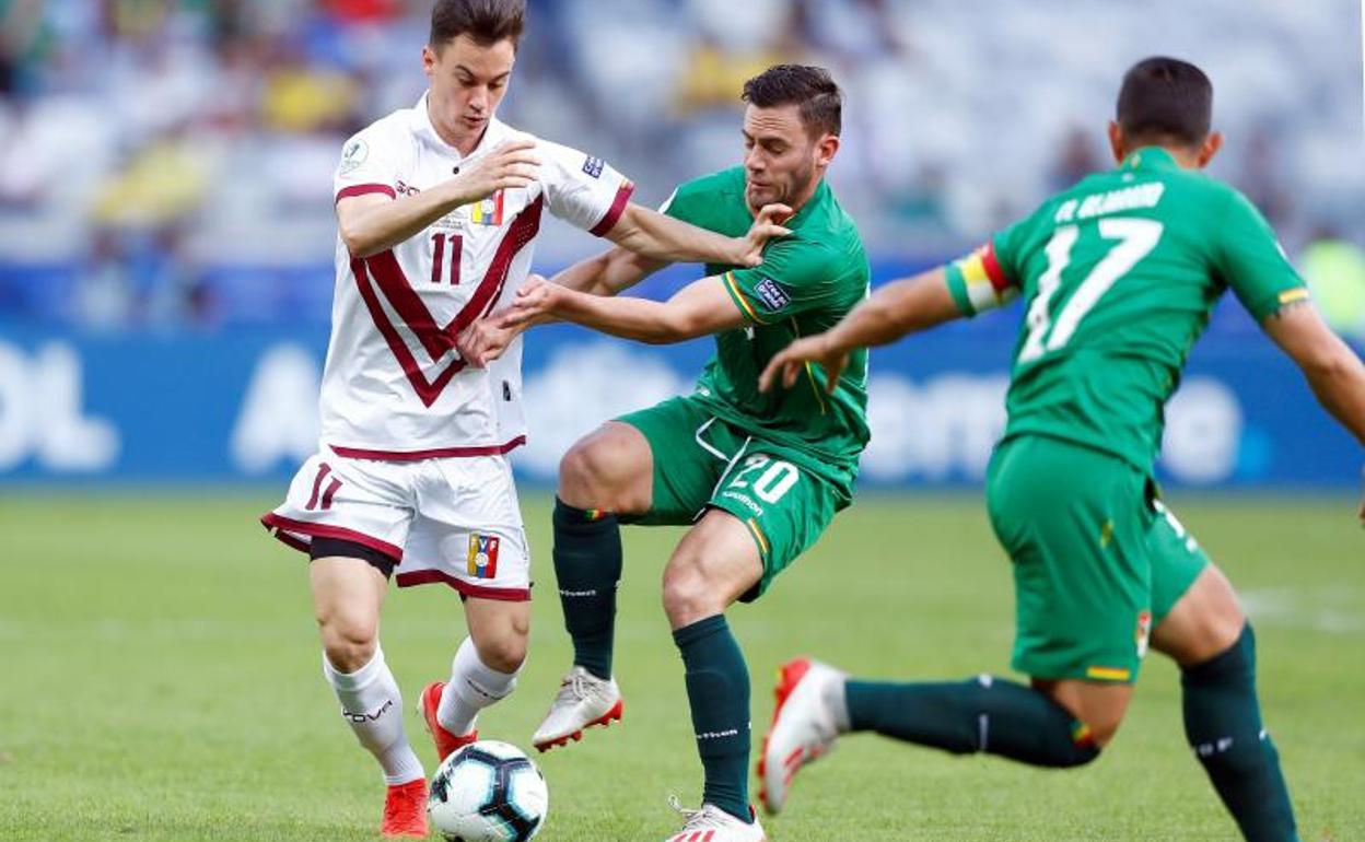Juanpi disputa un balón ante Saucedo durante el partido Bolivia-Venezuela.