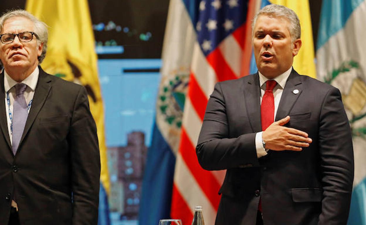 Iván Duque (d) escucha el himno de Colombia. 