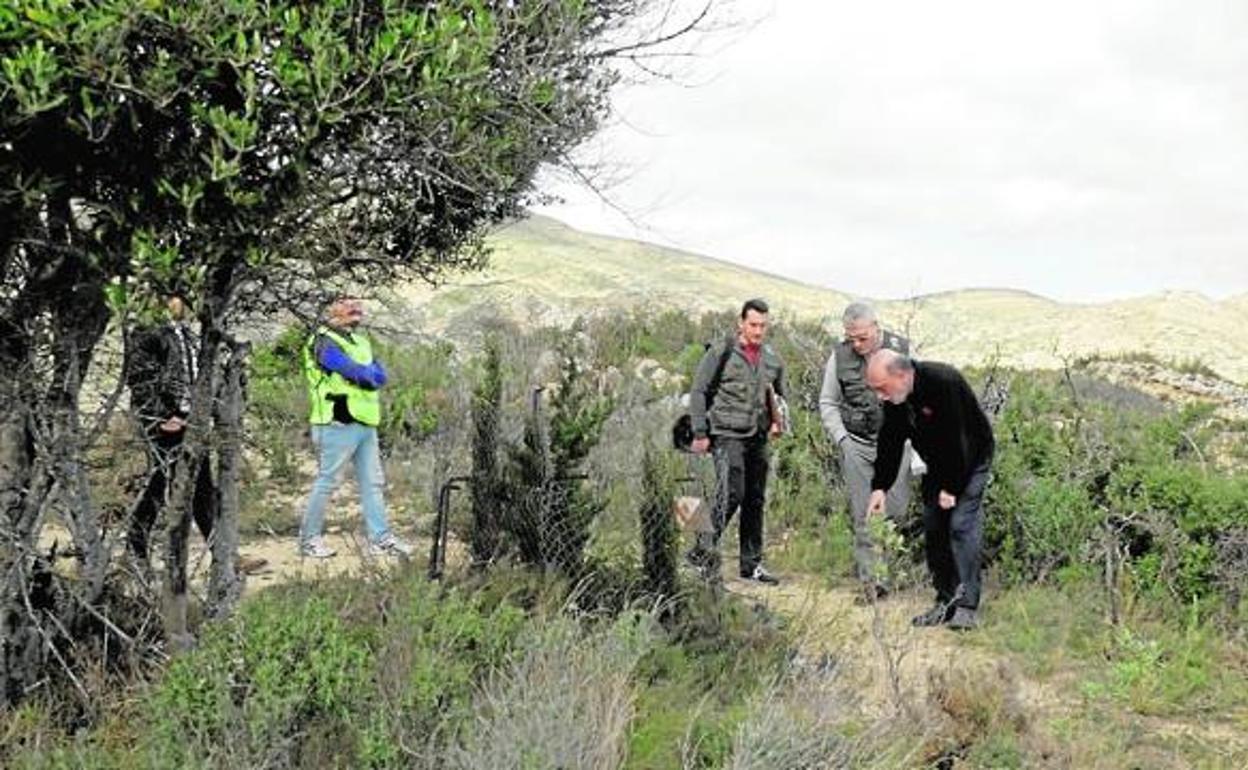 El antropólogo forense señala el lugar donde encontró el premolar ante la atenta mirada de dos guardias civiles. 