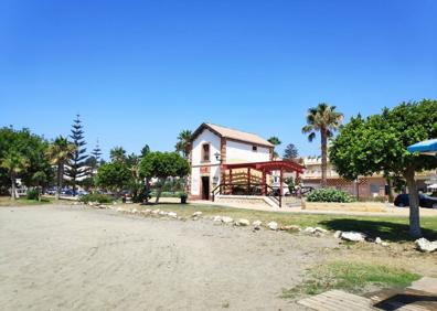 Imagen secundaria 1 - Arriba, paseo marítimo de Benajarafe. Abajo, la arena de esta playa es fina y oscura y la antigua estación ferroviaria en primera línea de playa.