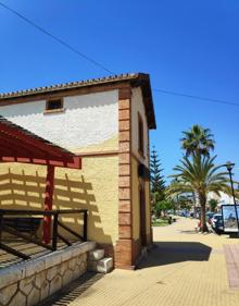 Imagen secundaria 2 - Arriba, paseo marítimo de Benajarafe. Abajo, la arena de esta playa es fina y oscura y la antigua estación ferroviaria en primera línea de playa.