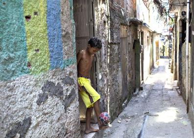 Imagen secundaria 1 - Arriba, soldados brasileños patrullando por Rocinha. Abajo, a la derecha, vista de la favela. A la izquierda, un niño jugando al balón. 