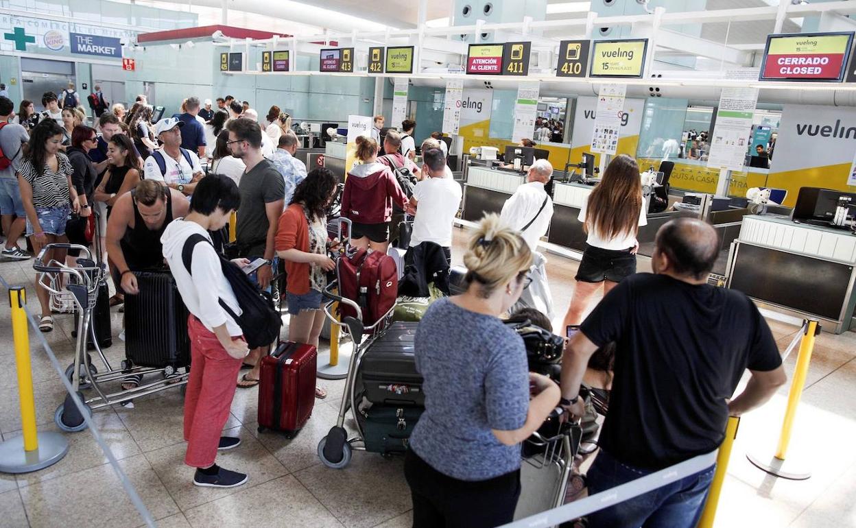 Pasajeros haciendo cola en el aeropuerto del Prat, en Barcelona.