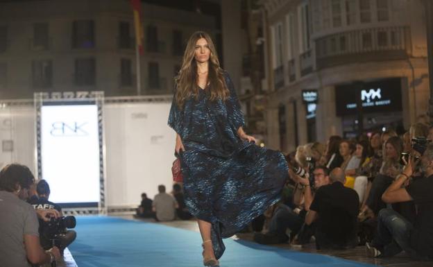 Imagen principal - Diseños de su colección y abajo, Antonio Banderas siguiendo atento el desfile desde un balcón del Hotel Larios.