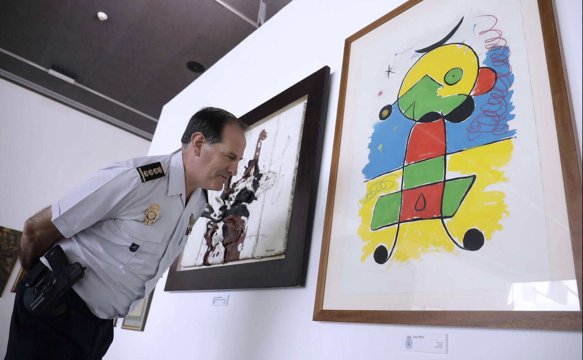 El comisario, Javier Peña Echeverría, observa un falso Miró encontrado en el chalet de Roca.