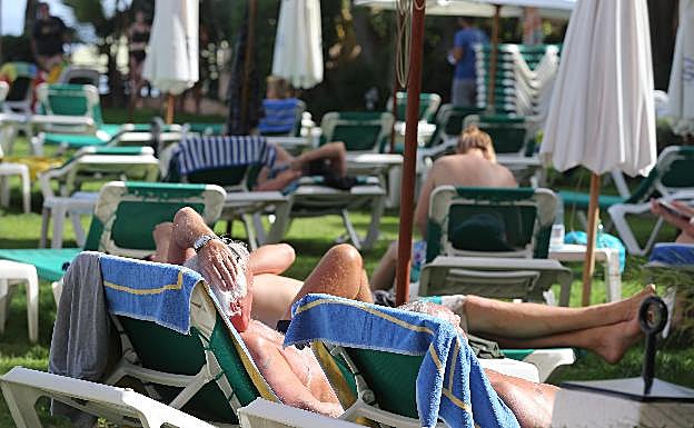 Turistas toman el sol en la terraza de un hotel de Torremolinos. 
