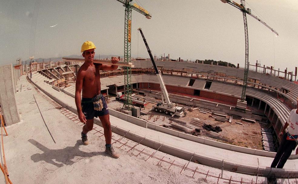 Un obrero transporta material durante la construcción del anillo superior del Palacio de los Deportes en 1998. 