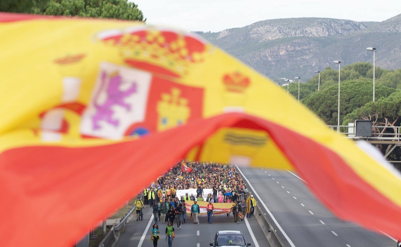 Un grupo de personas ondean banderas de España ante los centenares de personas convocadas por los CDR que caminan desde Casteldefels (Barcelona) para unirse a las "Marchas por la Libertad", las cinco marchas que comenzaron el miércoles en distintos puntos de Cataluña