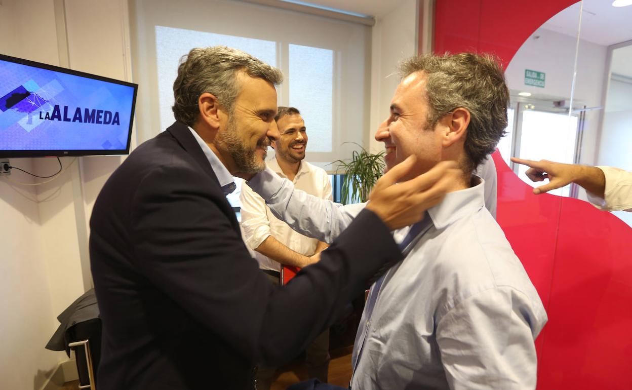 López y Díaz se abrazan ante la mirada de Garzón. 