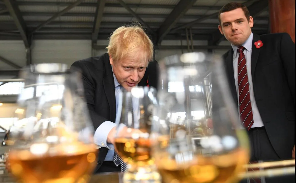 El primer ministro, Boris Johnson, toma un whisky en la destilería Roseisle durante un acto de su campaña en Escocia.