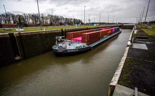 Imagen principal - Arriba, por el Albertkanaal, el mayor de Bélgica, navegan cada año 130.000 barcos, que mueven 4 millones de toneladas de mercancías. Abajo, a la izquierda, Lilianne Stinissen, portavoz de la compañía que gestiona los canales. A la derecha, los camiones contribuyen a congestionar las autovías belgas.