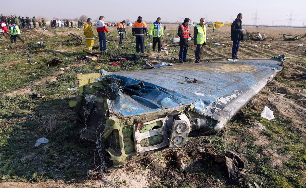 Investigadores forenses y miembros de los equipos de rescate inspeccionan los cuerpos de los fallecidos en el siniestro aéreo.