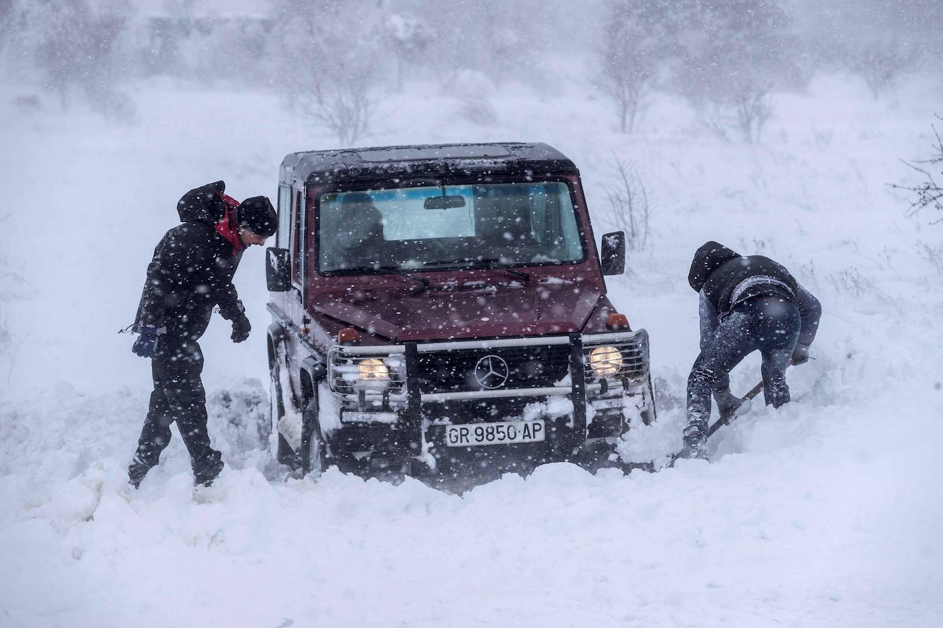 Dos hombres intentan sacar su todo terreno atrapado en la nieve en las proximidades de Yecla (Murcia)