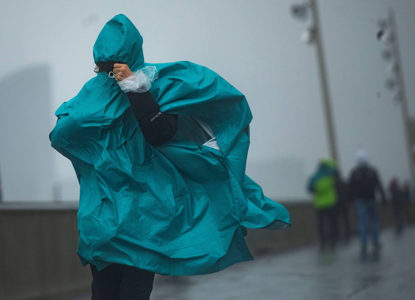 Una persona camina por el paseo marítimo de la Barceloneta, en Barcelona