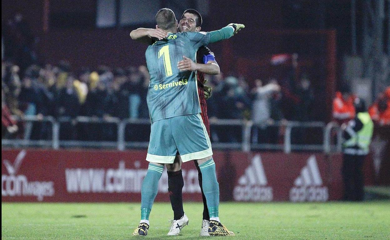 El portero del Mirandés Limones (i) celebra con su compañero Kijera la victoria de su equipo ante el Celta de Vigo, al término del partido de dieciseisavos de final de la Copa del Rey disputado este jueves en el estadio municipal de Anduva, en Miranda de Ebro. 