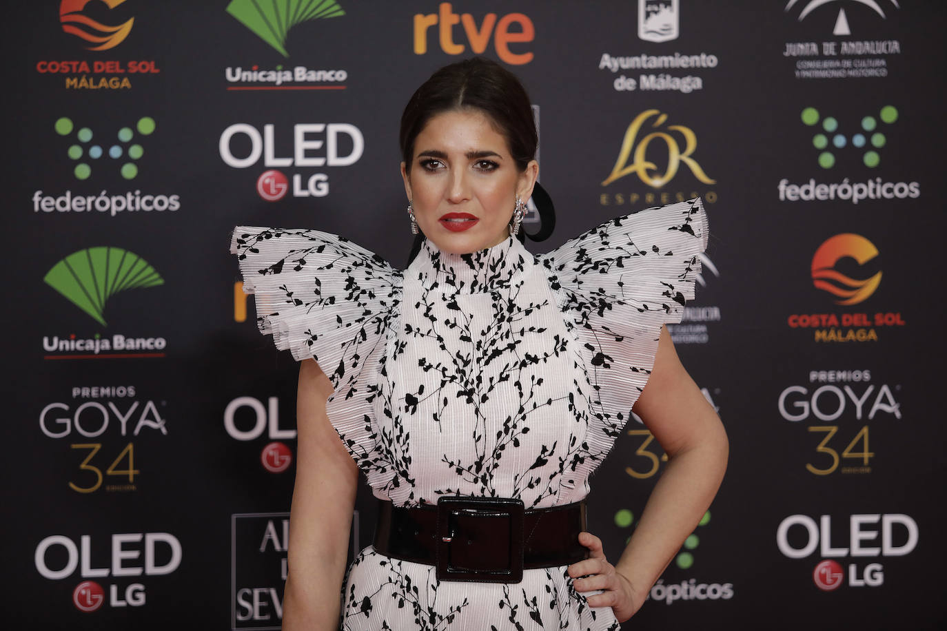 Lucía Jiménez, favorecida con diseño bicolor floral con acabado plisado y mangas con volumen. Ideal su peinado: una coleta con maxi lazada negra