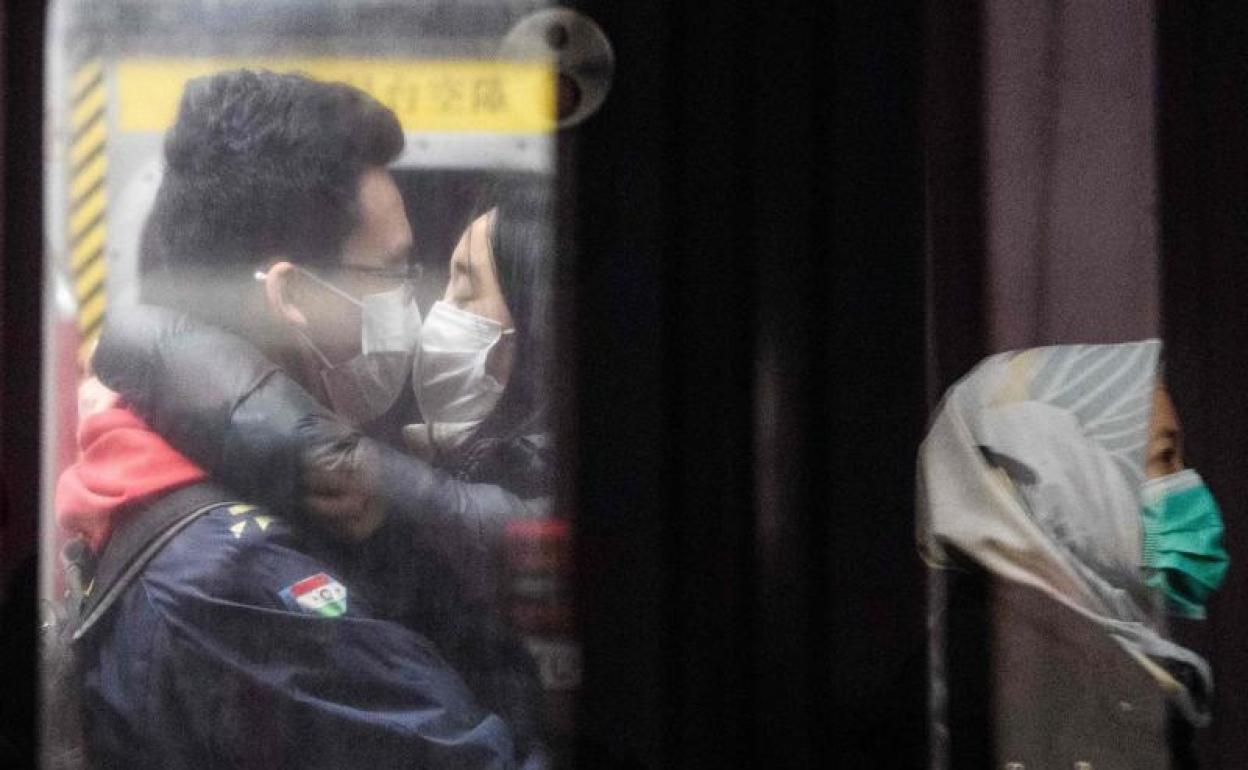 Una pareja se besa en el metro. 