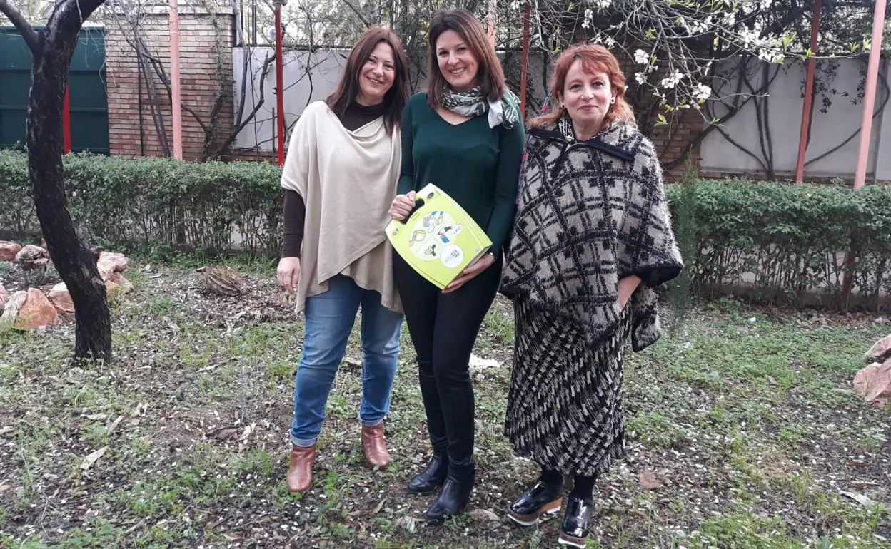 Las profesoras Maria José Molina, Lola Rico y Asunción Trevilla, con el desfibrilador del centro. 