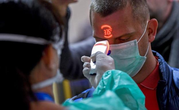 Una sanitaria húngara toma la temperatura a un ciudadano que regresa de Milán. 