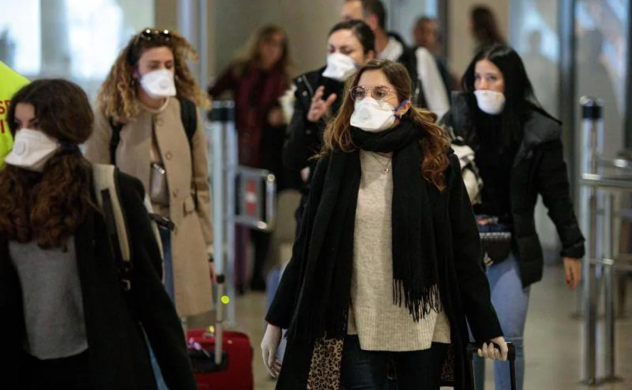 Viajeros procedentes de Italia protegidos con mascarillas a su llegada al aeropuerto de Manises (Valencia). 