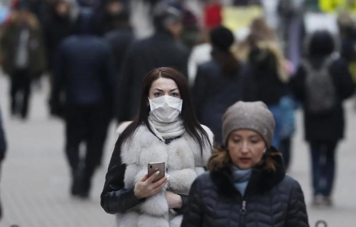 Una mujer con una máscara protectora camina en la calle en el centro de Moscú