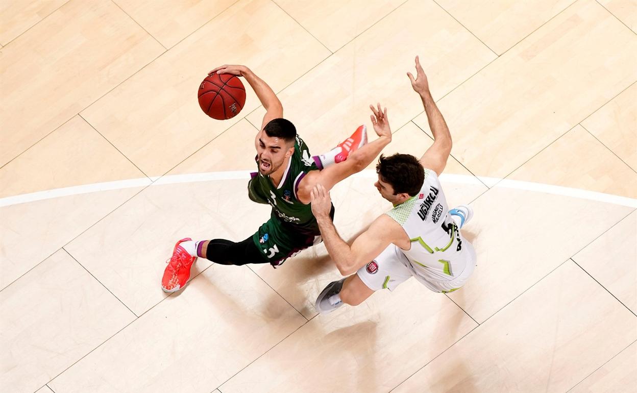 Jaime Fernández trata de escapar de la defensa de un jugador del Tofas en un partido en el Palacio de los Deportes esta temporada.