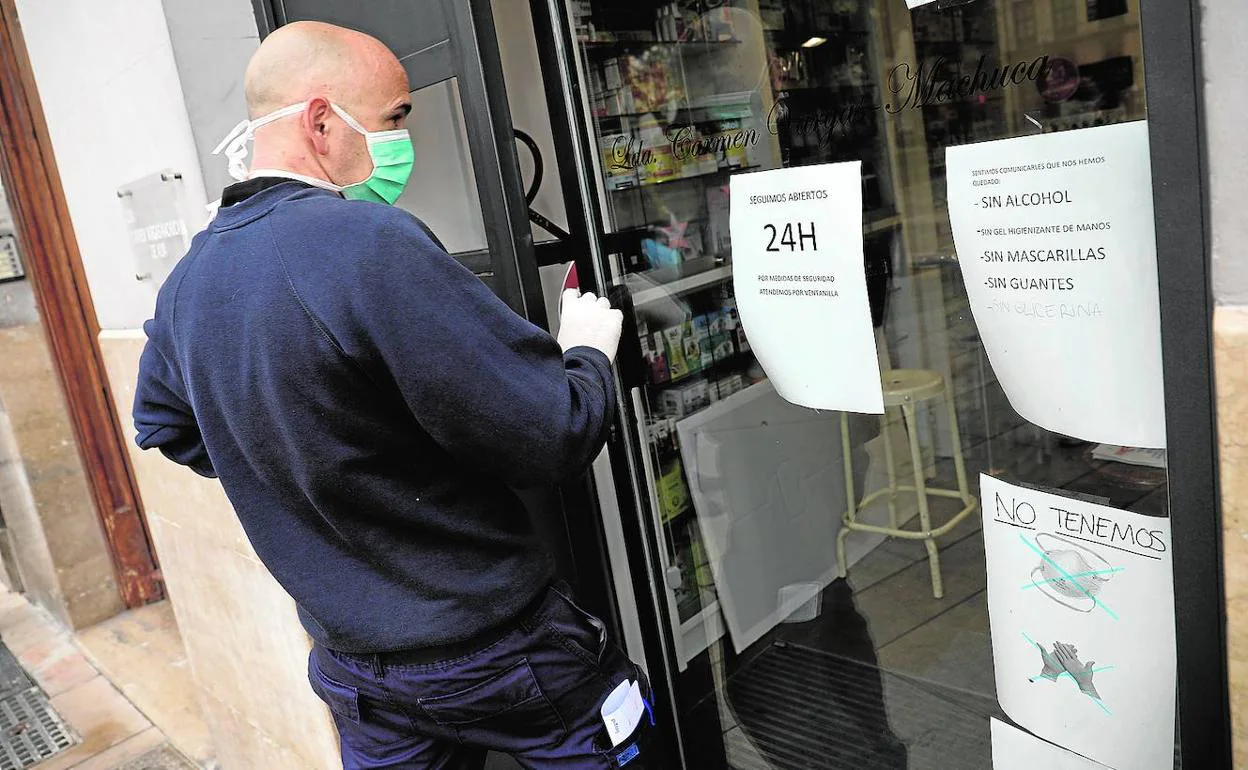 Carteles en la puerta de una farmacia avisan de la falta de mascarillas, guantes, alcohol y gel desinfectante 