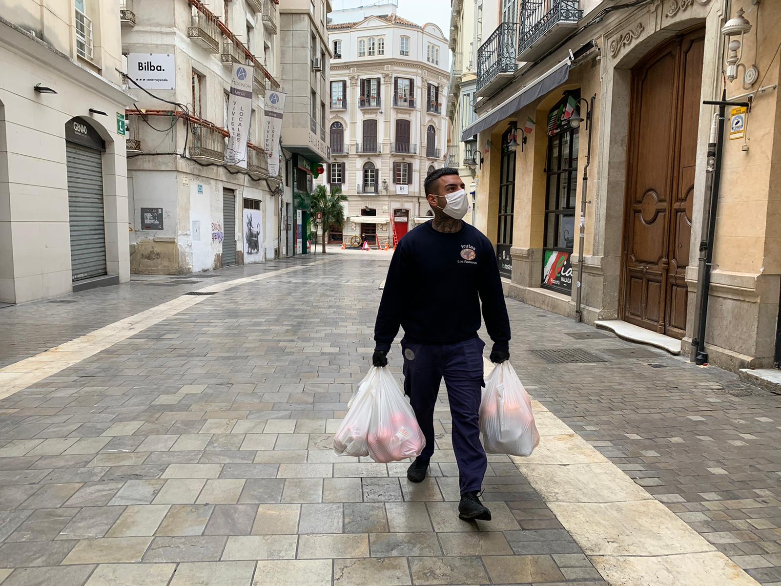 Un hombre lleva la compra por las calles del Centro