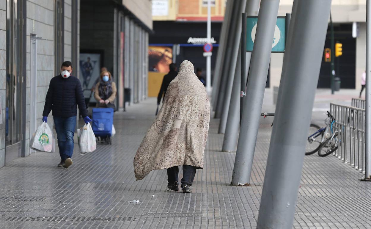 Una persona sin hogar camina por la zona de la estación de trenes.