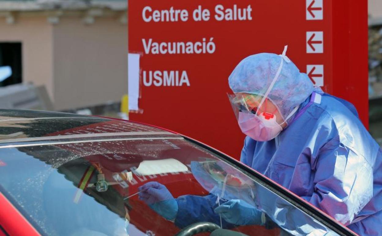 Miembros del hospital de la Malvarrosa, en Valencia, realizan test rápidos a las puertas del centro sanitario sin que los conductores bajen del vehículo.