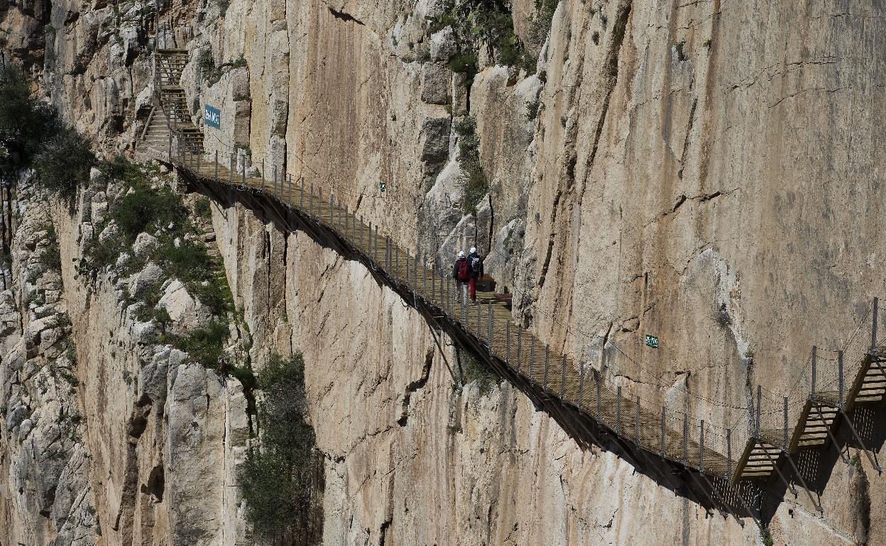 Visitantes recorriendo una de las pasarelas sobre la pared vertical.