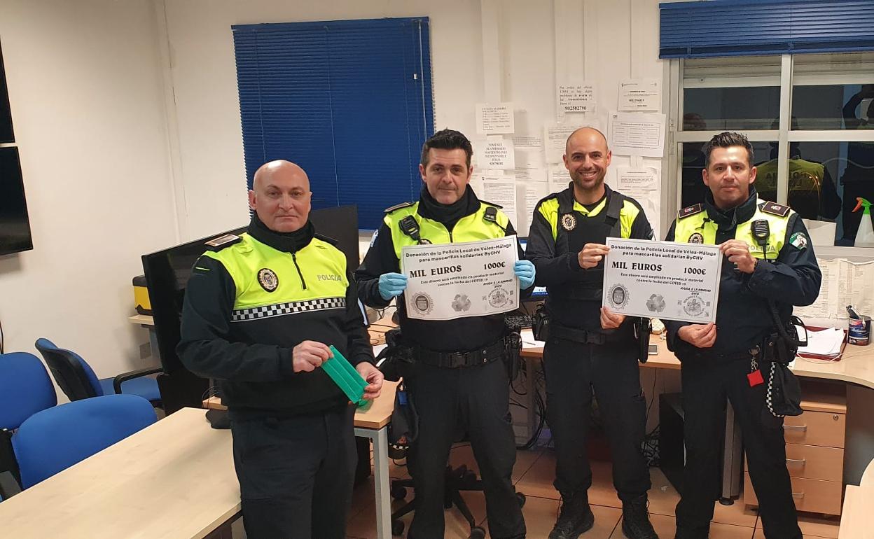 Agentes de la Policía Local de Vélez-Málaga, con el talón de mil euros. 