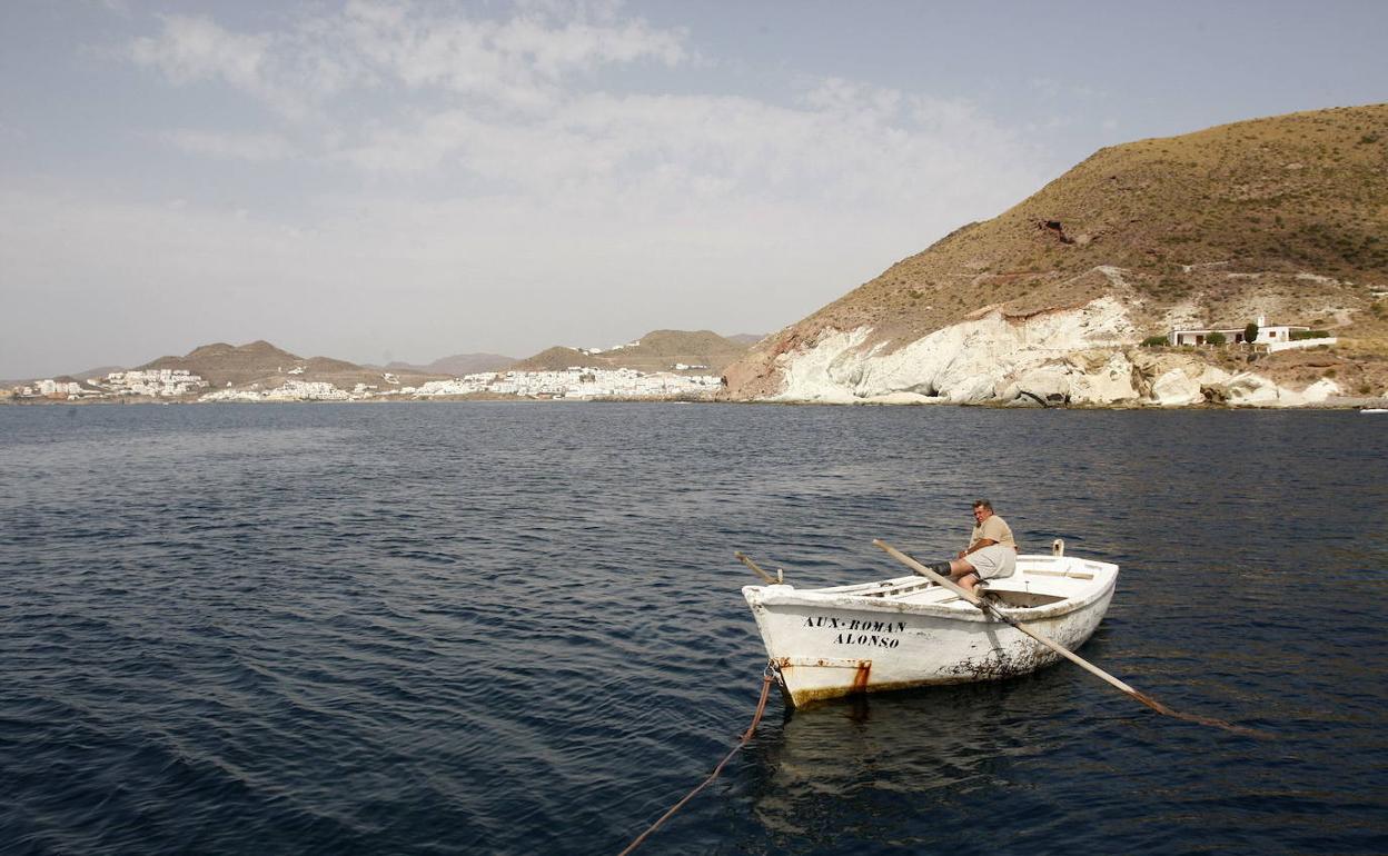 Un pescador artesanal faena en su barco frente a la costa del Parque Natural Cabo de Gata. 