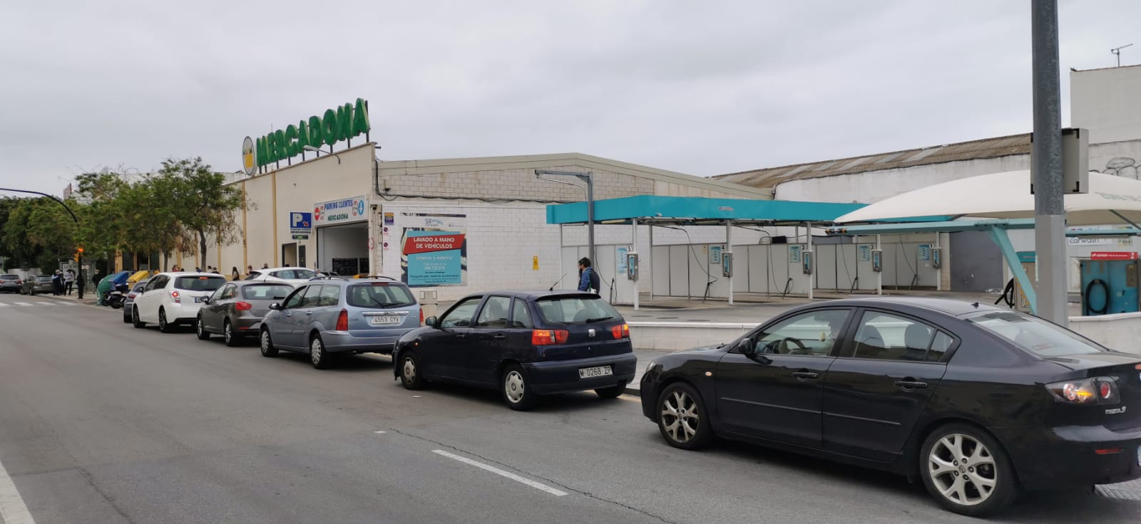 El estado de alarma deja estampas inéditas. Cola de coches para comprar en un supermercado.