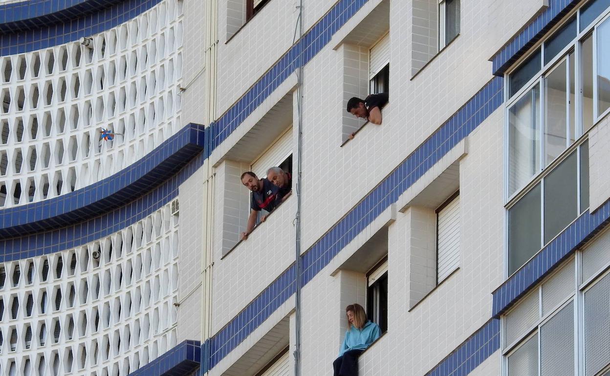 Una mujer sentada en el alféizar de la ventana medita si se suicida. 