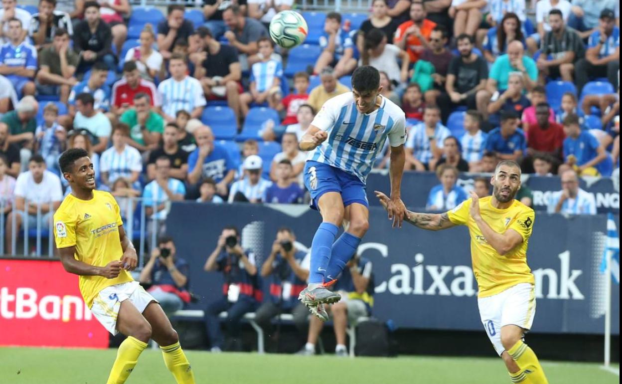 Diego González despeja de cabeza en el derbi en casa frente al Cádiz.