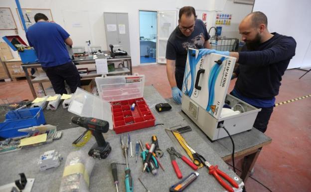 Operarios trabajan en el montaje de un equipo de producción de ozono.