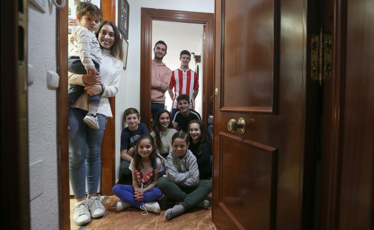 Los diez hijos de la familia Castillo Cobos, en la puerta de su piso. 