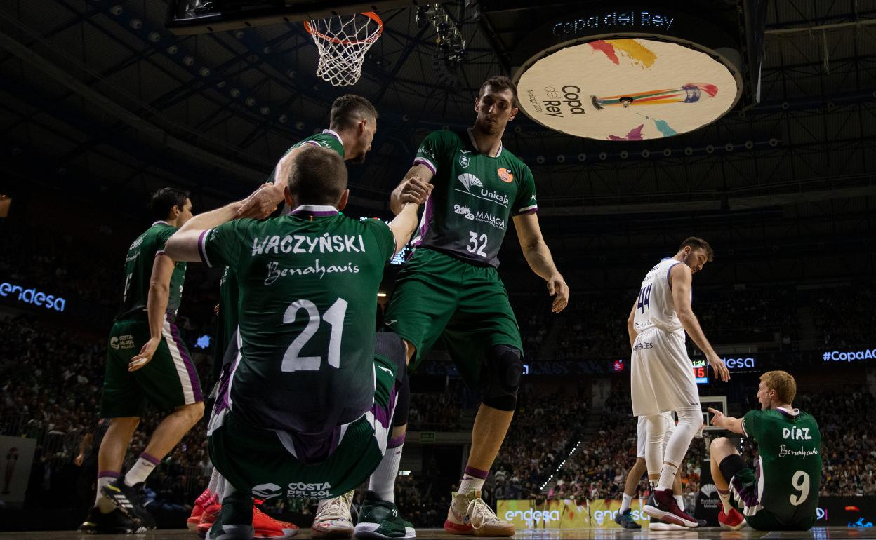 Adams y Guerrero ayudan a Waczynski a levantarse en un partido contra el Andorra. 