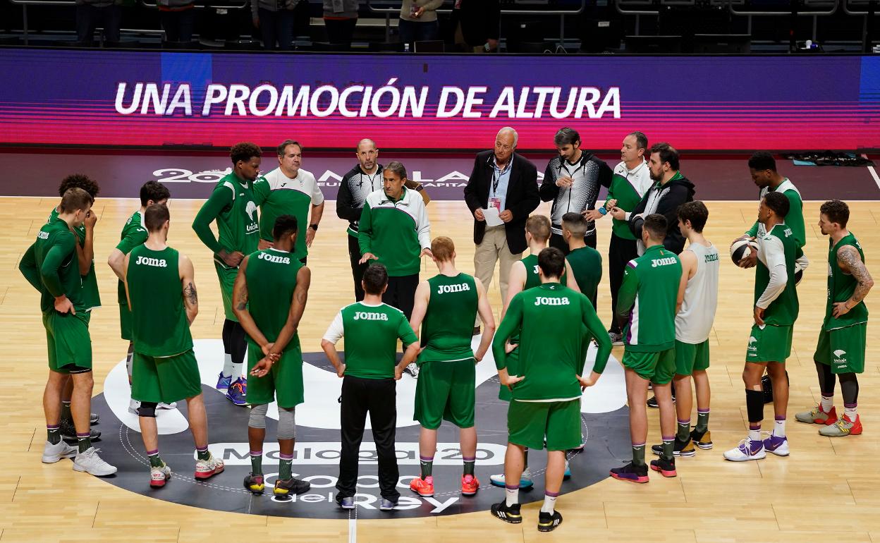 La plantilla del Unicaja atiende a Luis Casimiro durante un entrenamiento en el Palacio de los Deportes. 