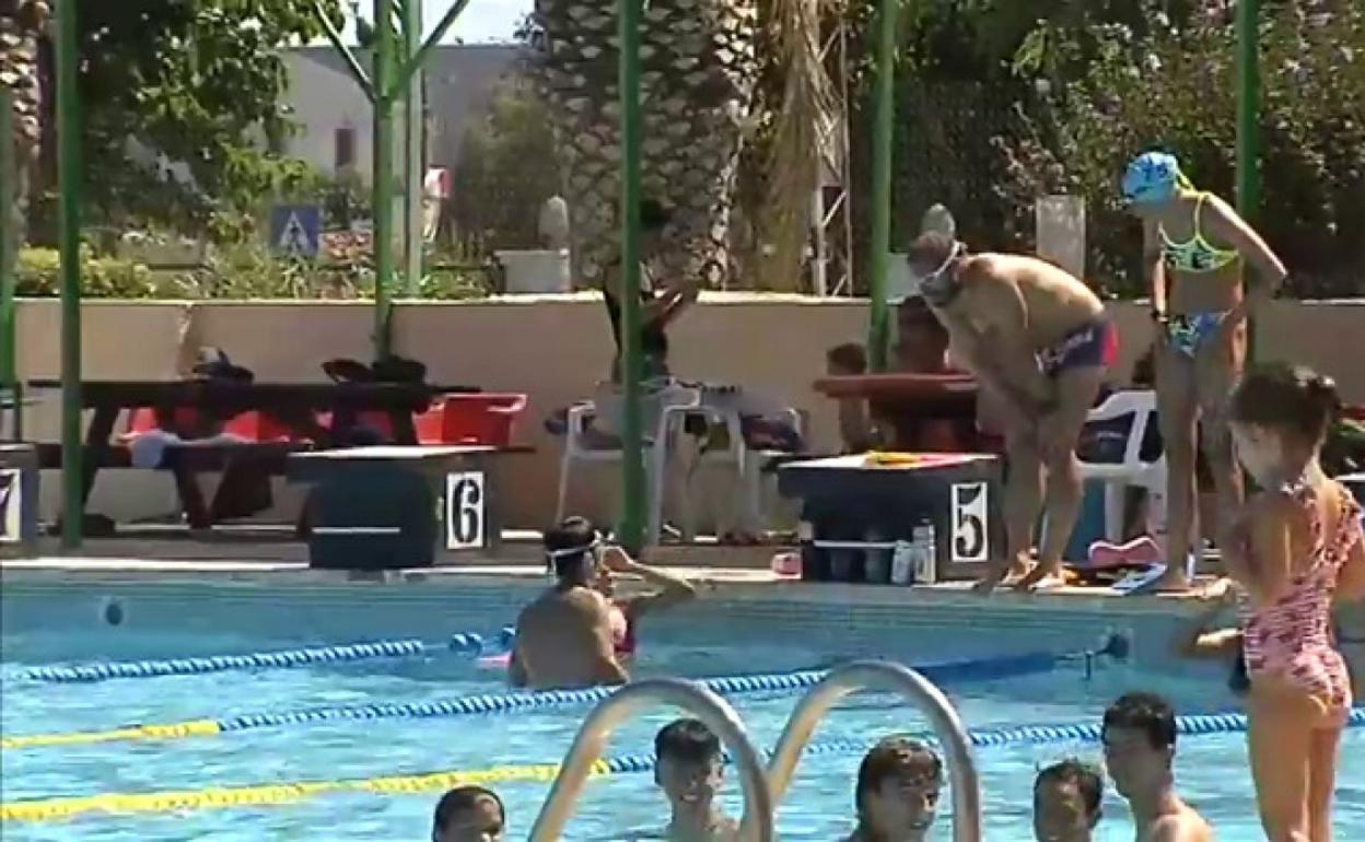 Varias personas se dan un baño en una piscina. 