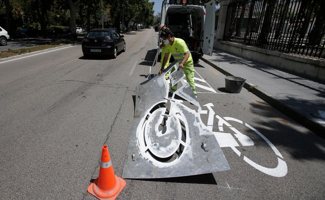 Un operario retira el molde con el que se ha señalizado la prioridad para bicis en Manuel Agustín Heredia. 
